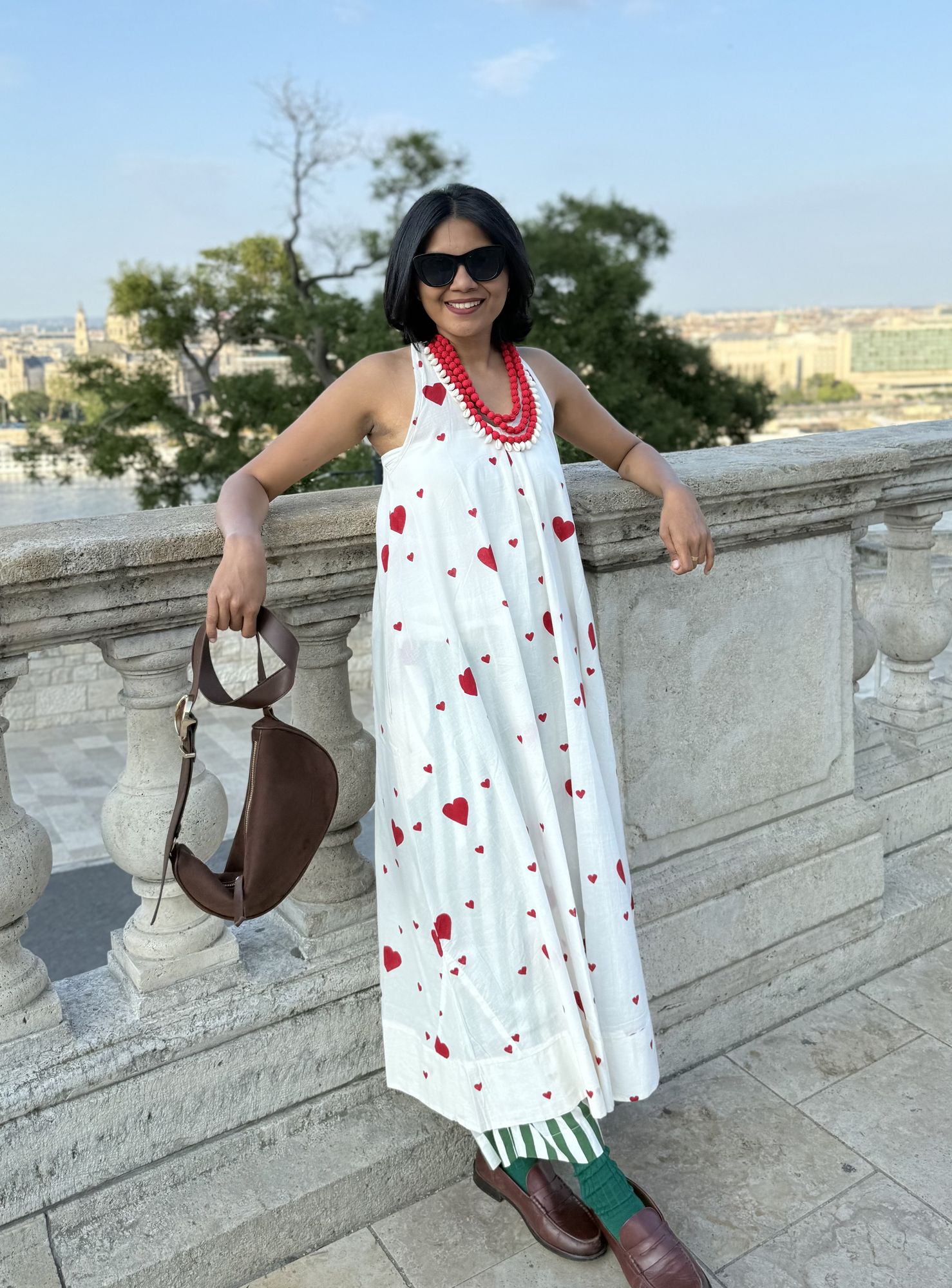 White heart-print dress, red beaded necklace